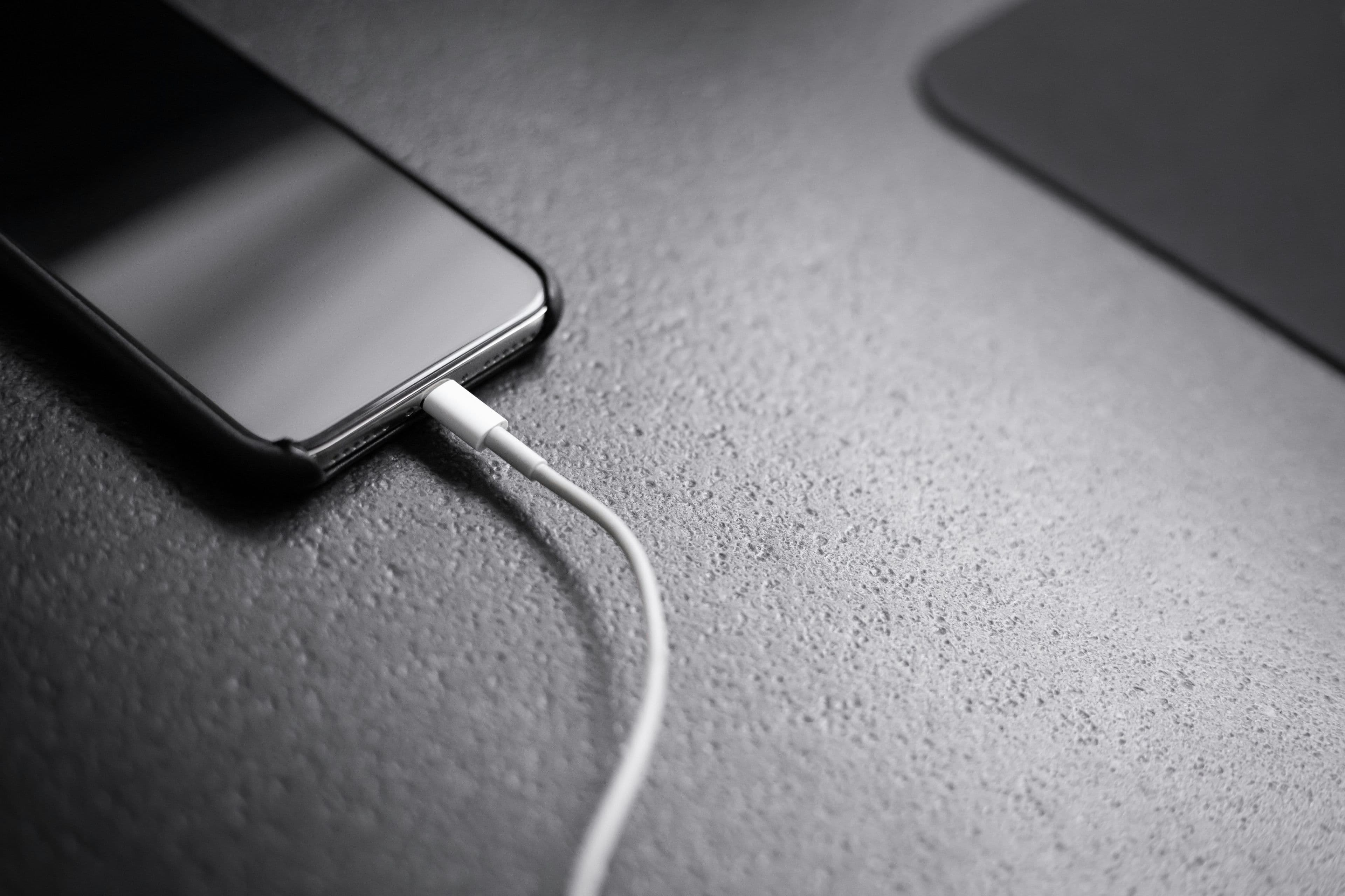 Phone chargers and cables coiled on a desk