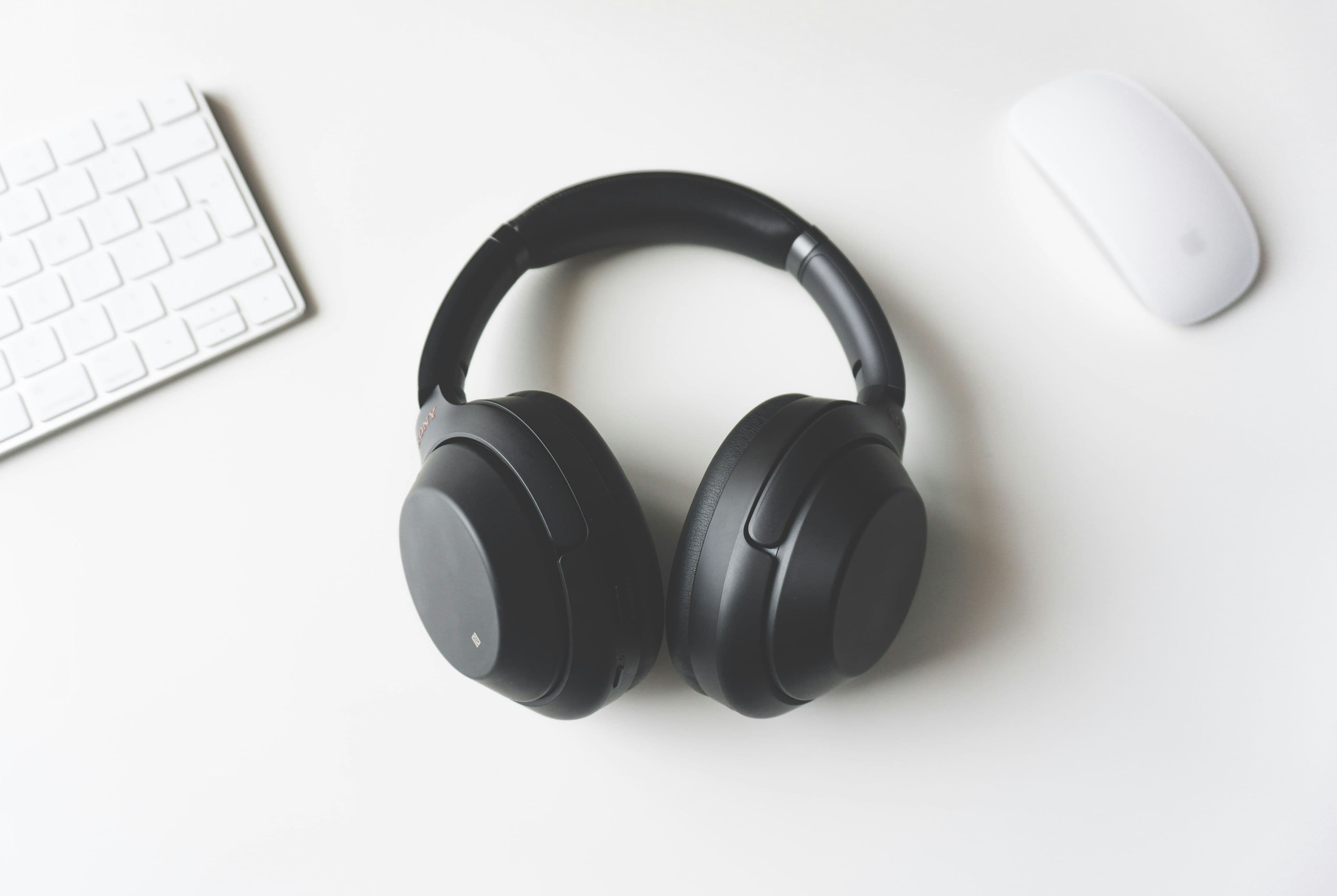 A pair of wireless headphones resting on a desk