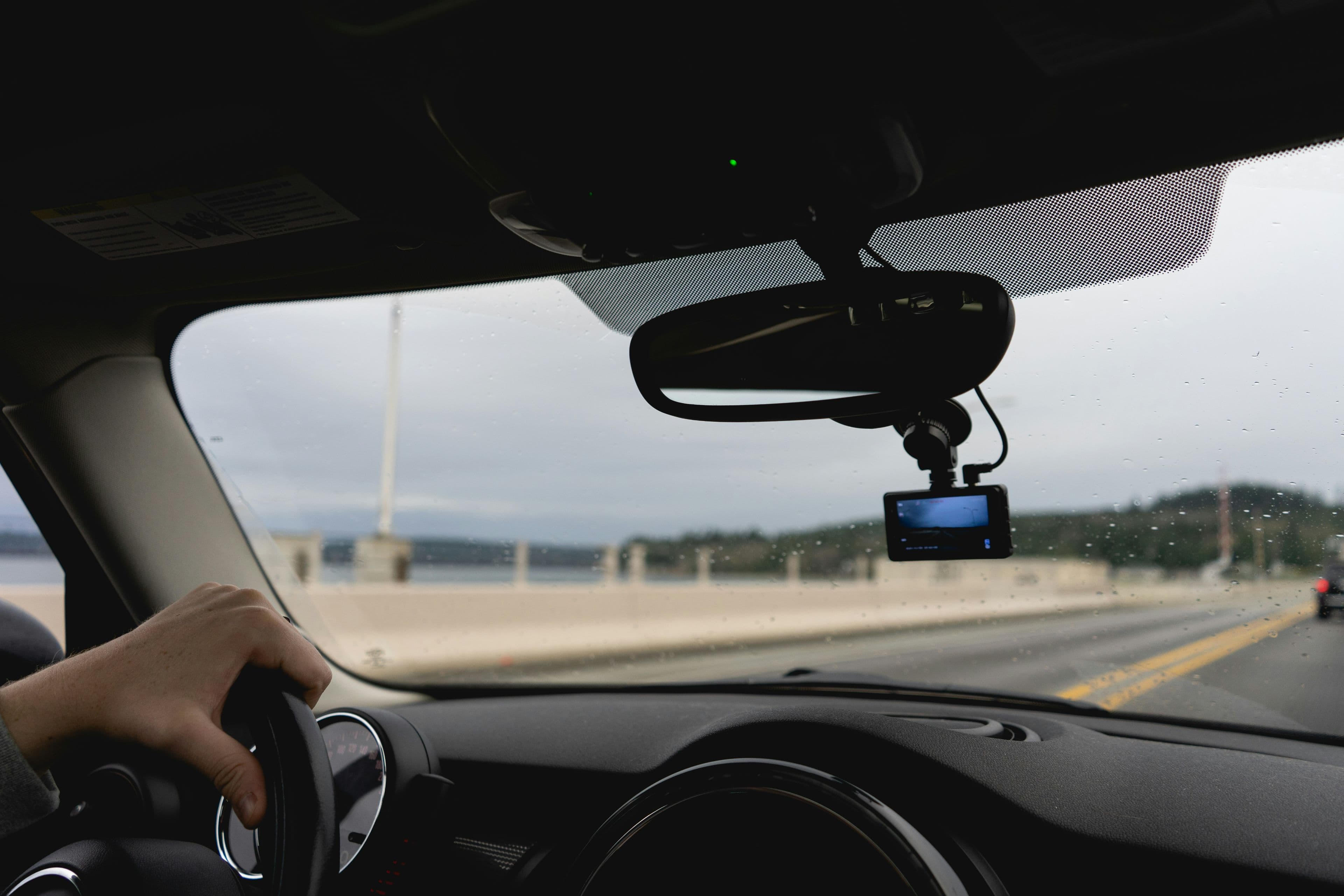 A dash cam mounted on a car windshield