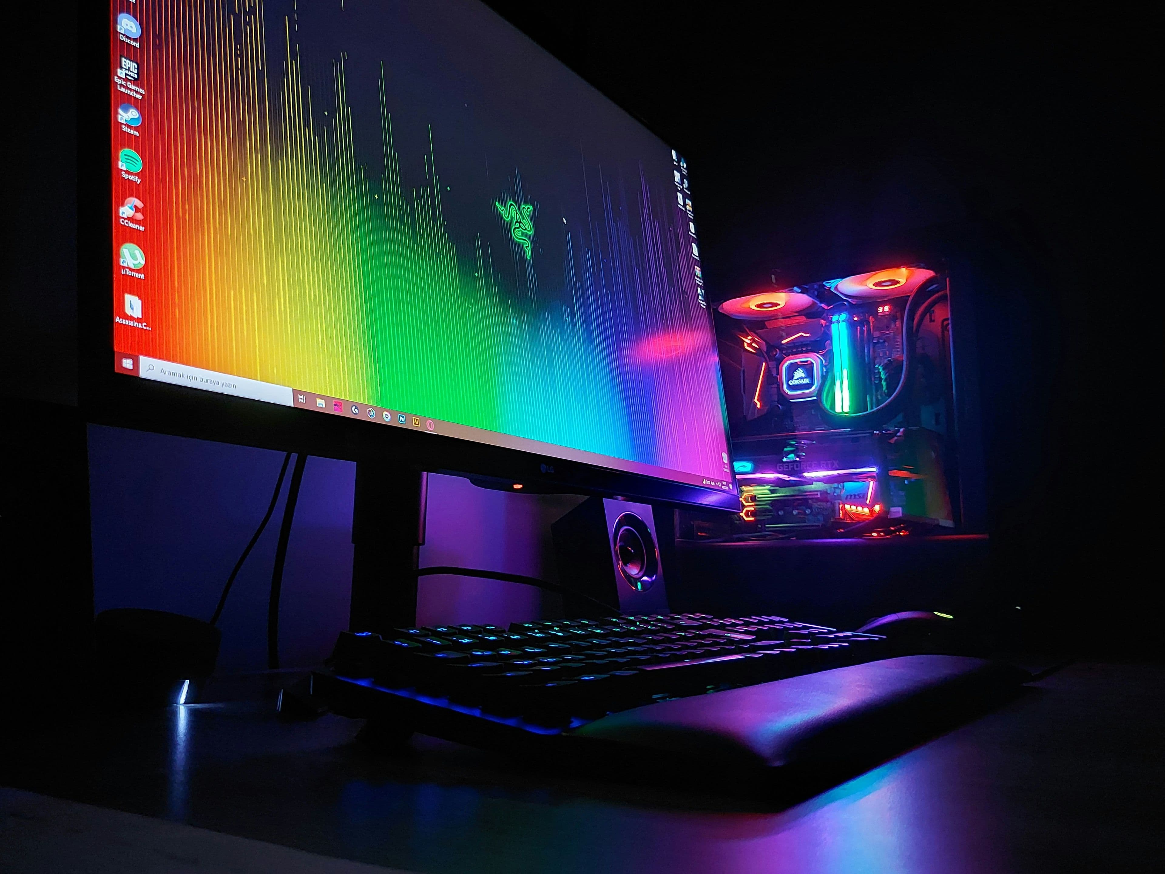 A gaming monitor glowing on a desk setup