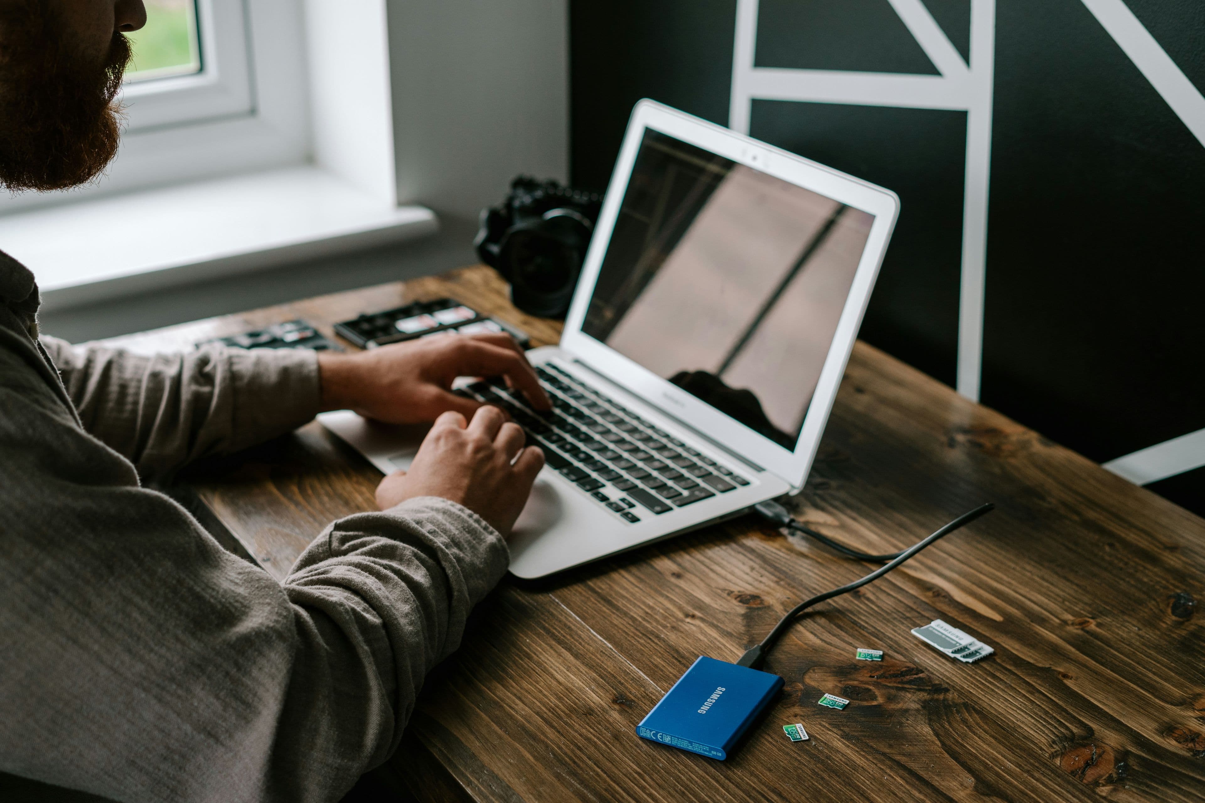 A portable external SSD next to a laptop